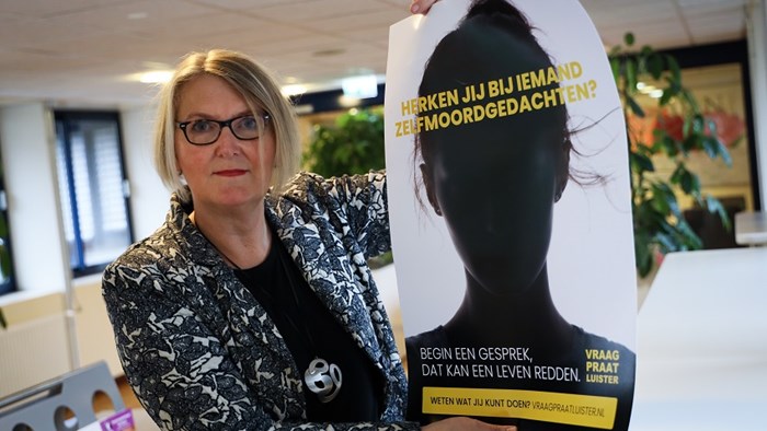 Wethouder Van der Ven toont campagneposter VraagPraatLuister