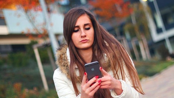 Jonge vrouw raadpleegt mobiel
