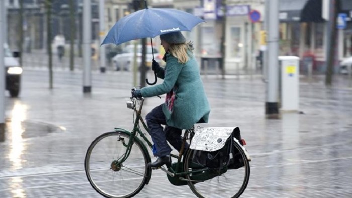 Vrouw fietst door de regen