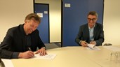 Arjan Putter van aannemersbedrijf J.M. Putter en Gerard Oud (CvB Clusius College) ondertekenen de aannemingsovereenkomst