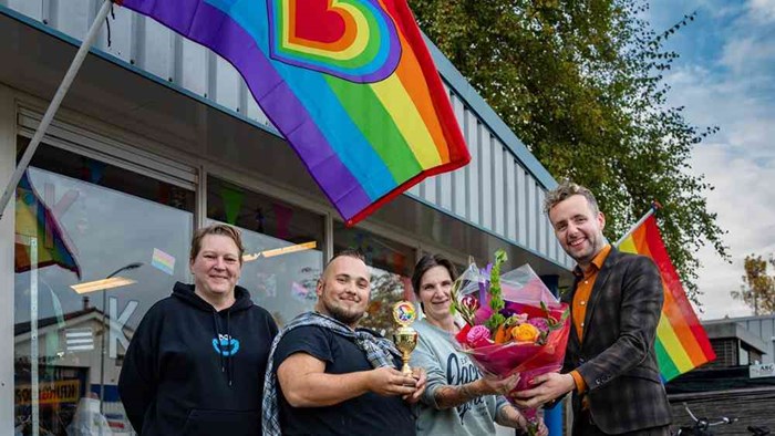 Wethouder Axel Boomgaars (rechts) feliciteert de winnaars van Kinderkledingbank Hoorn