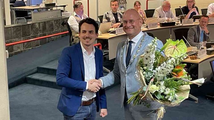Mitchel Sluis (VVD) ontvangt bij zijn afscheid bloemen van burgemeester Jan Nieuwenburg